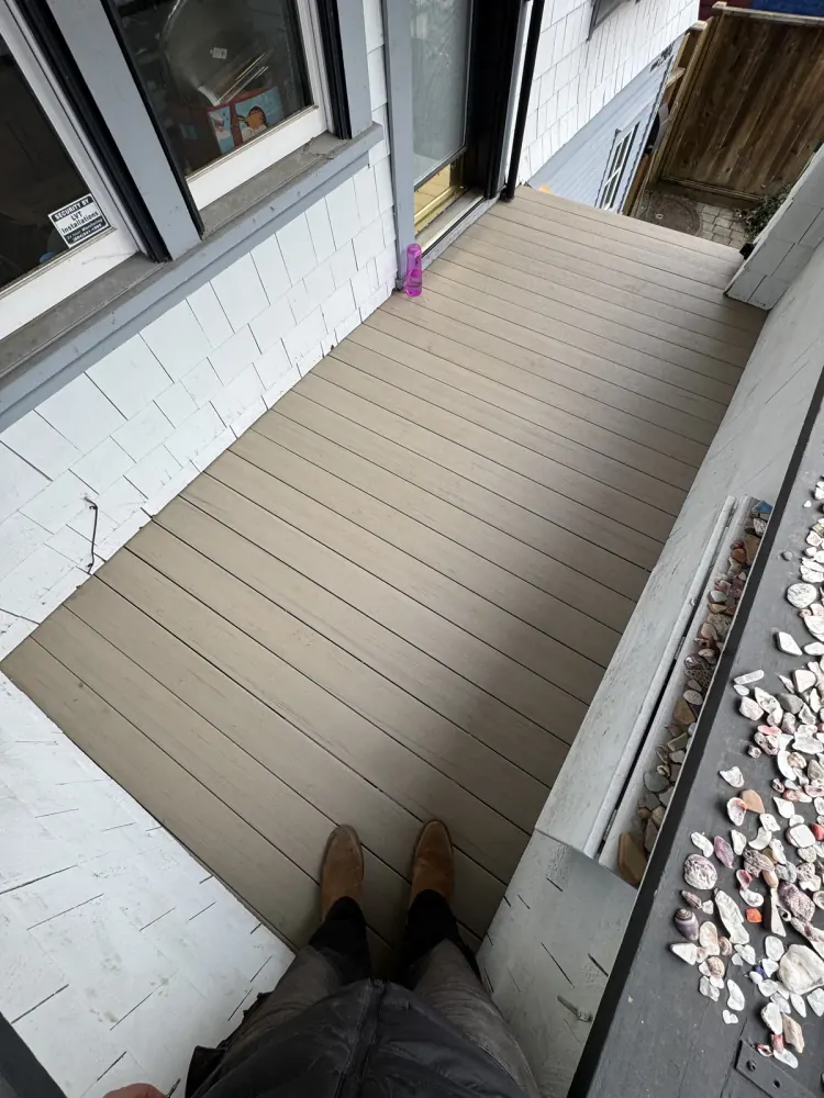 Tan composite deck boards on a covered side entry deck, viewed from above